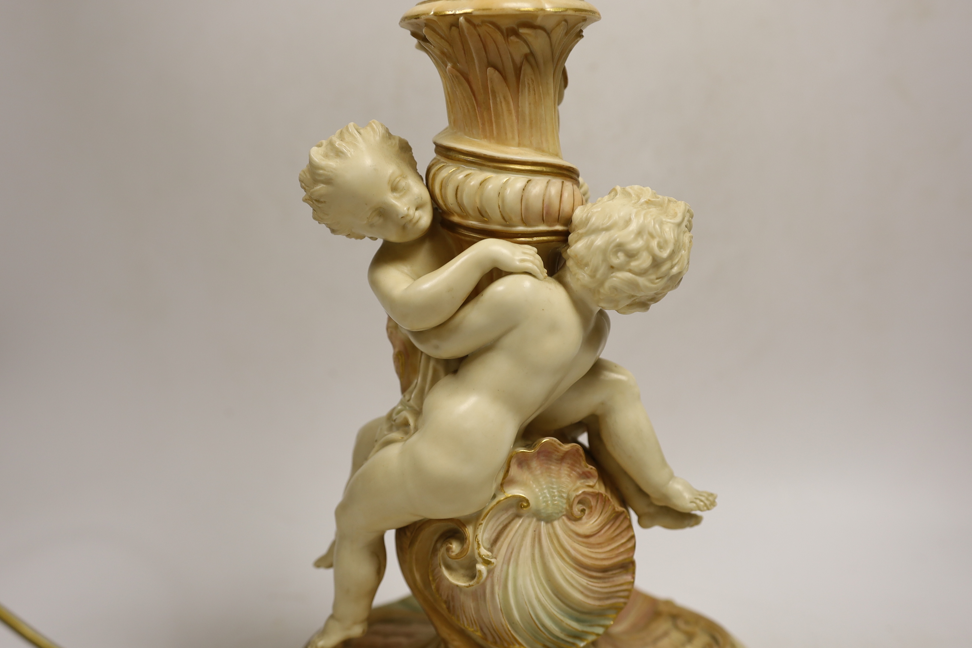 A large Royal Worcester blush ivory cherub lamp base, 40cms not including light fitting